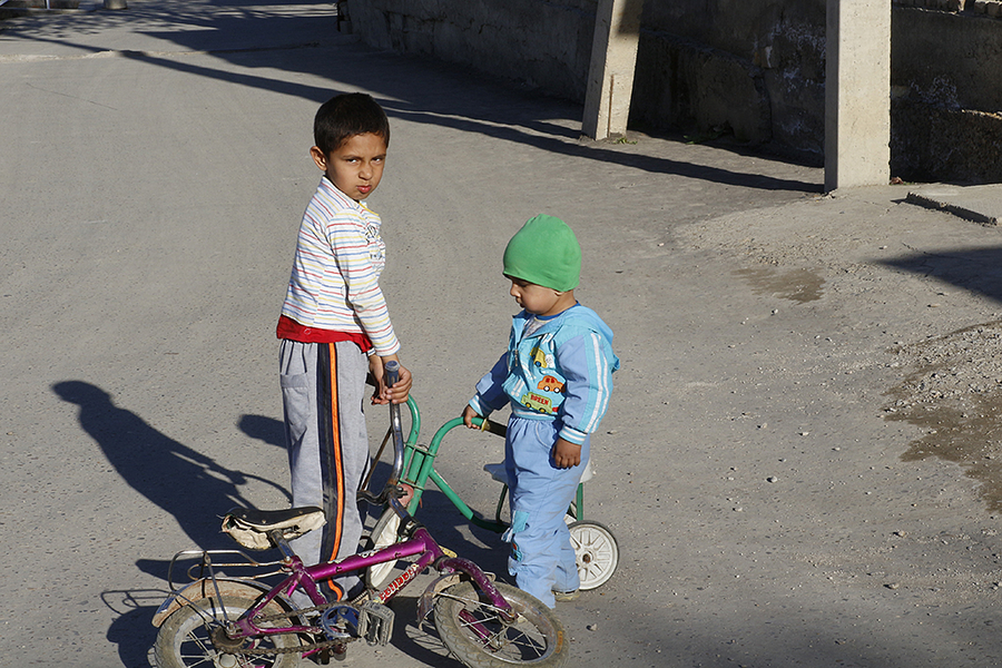 Dos niños jugando con las bicis en Bukhara Dos niños jugando con las bicis en Bukhara