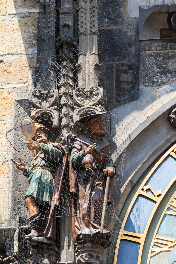 Hombre con espejo y comerciante judio en el reloj de Praga