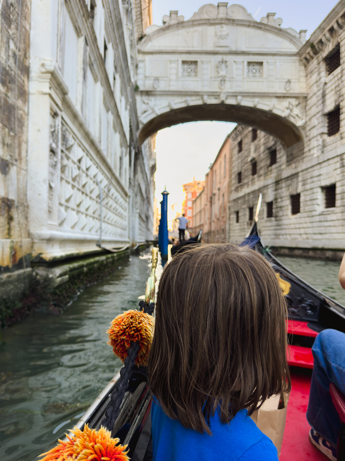 nina en gondola por puente de los suspiros